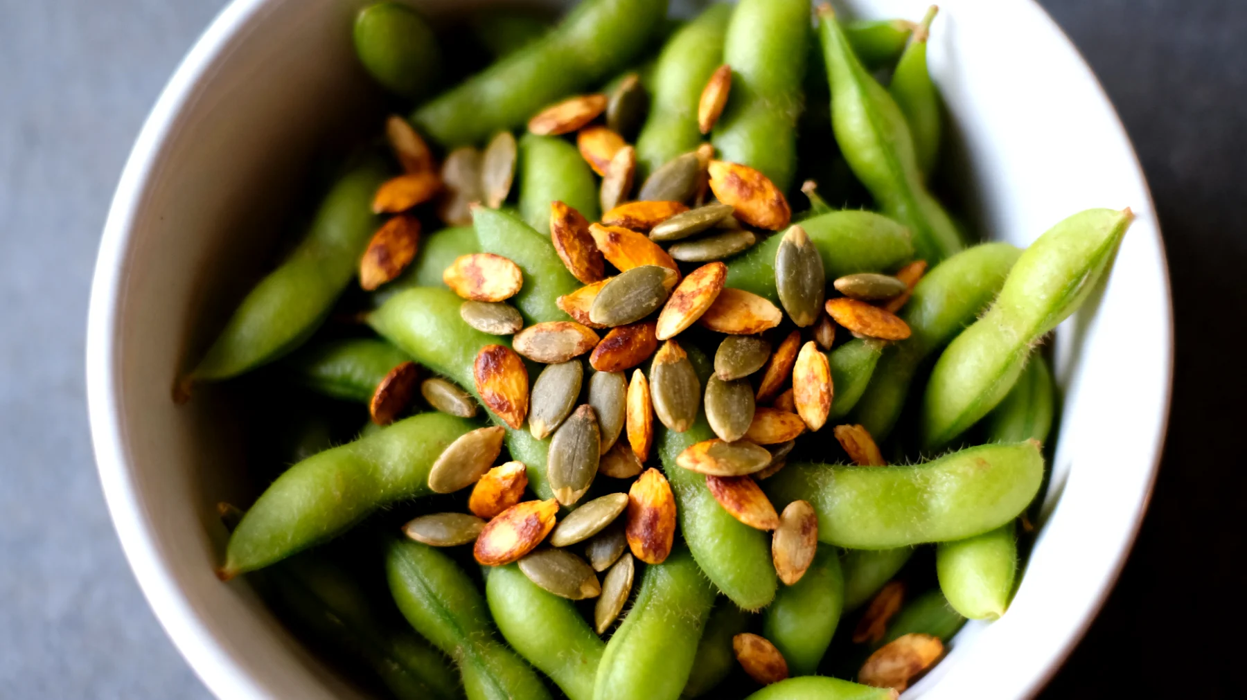 Edamame (fagioli di soia verde) con semi di zucca tostati"